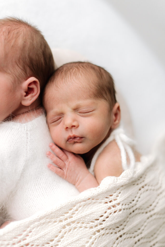 Newborn sleeping on their twin brother at West Sussex newborn photoshoot