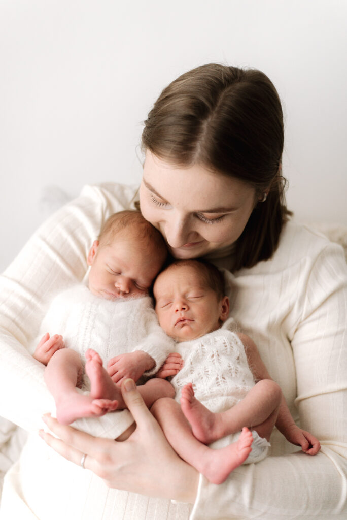 Mum holding both her newborn twins at West Sussex newborn photoshoot