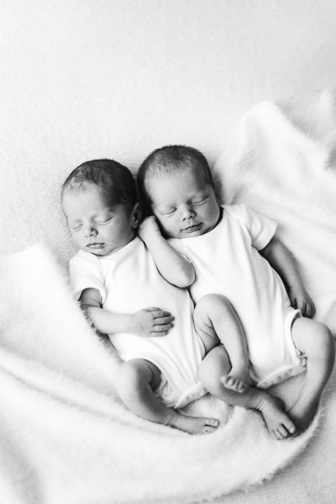 Twin boy and girl sleeping on a blanket at Newborn photoshoot in Billingshurst