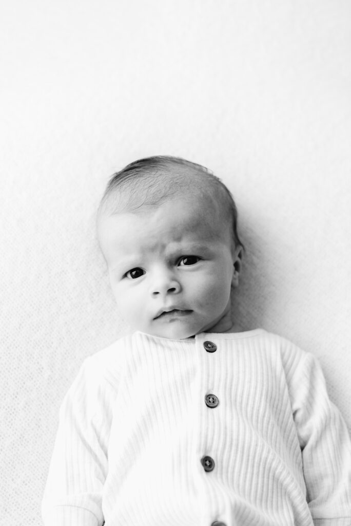 5 week old baby laying on a white blanket at Horsham newborn photoshoot