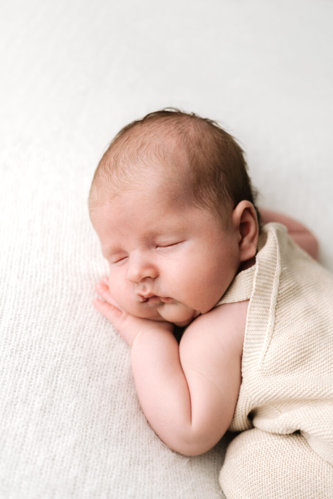 A baby boy laying on his front sleeping at a Horsham newborn photoshoot