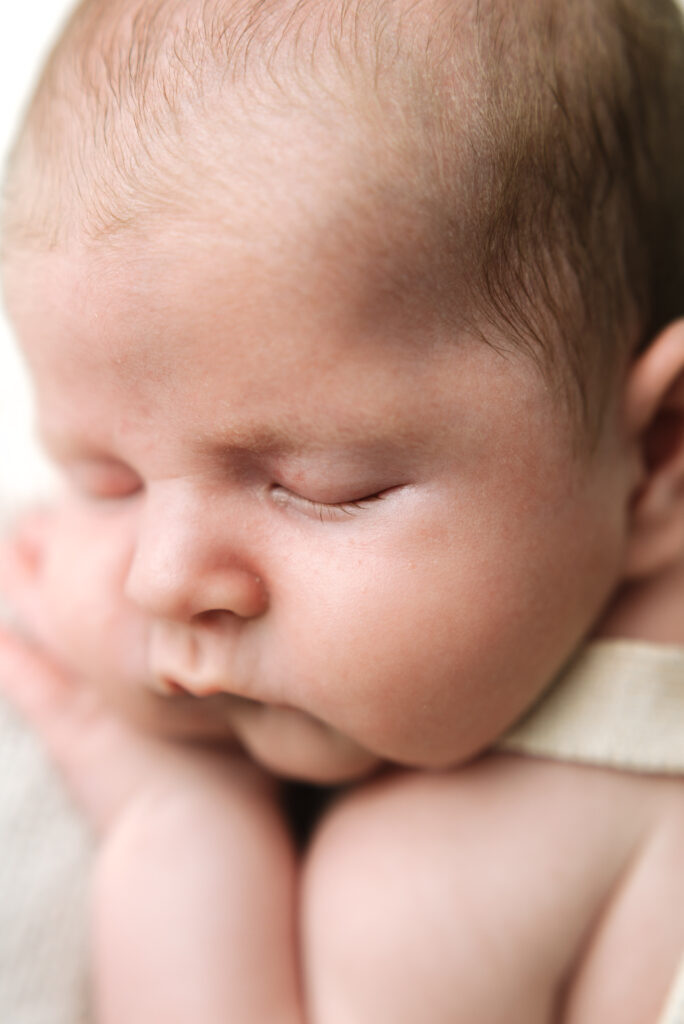 A close up photo of a sleeping babies face at Horsham newborn photography session