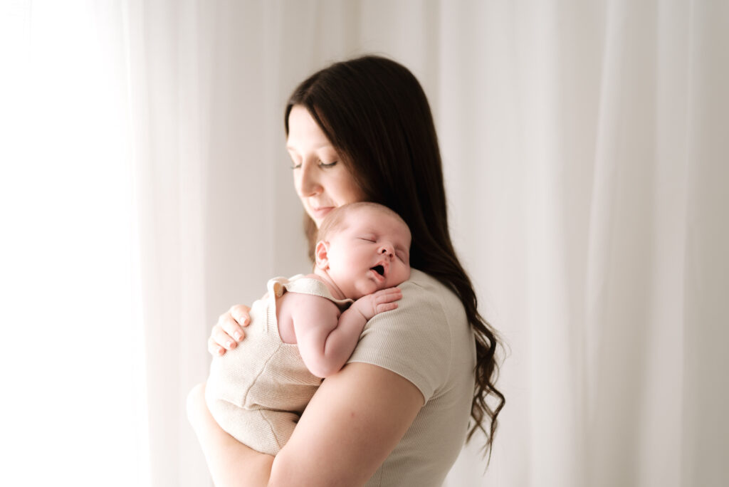 Mum holding sleeping baby on her shoulder at Horsham newborn photography session