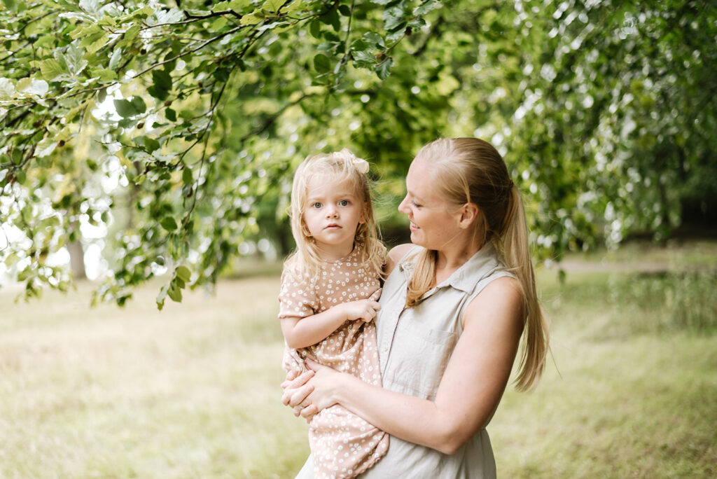 A mum holding her daughter and looking at her at a family photoshoot in Billingshurst
