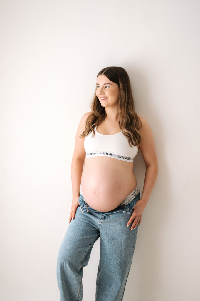 Expectant mother smiling at maternity photoshoot in Horsham