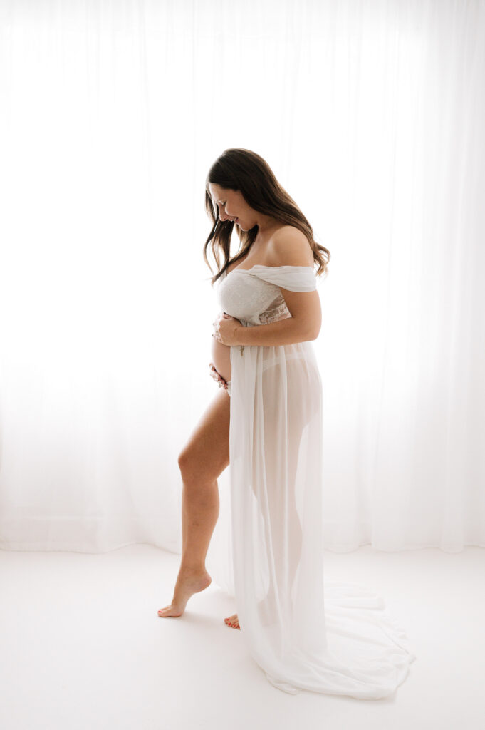 Silhouette portrait of a regnant mother in a long white dress at a natural Horsham Maternity photoshoot